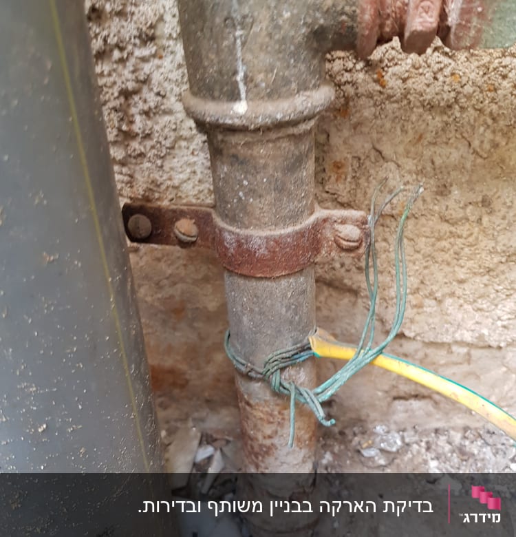 צינור מתכת עם חוטי חשמל ירוקים וצהובים